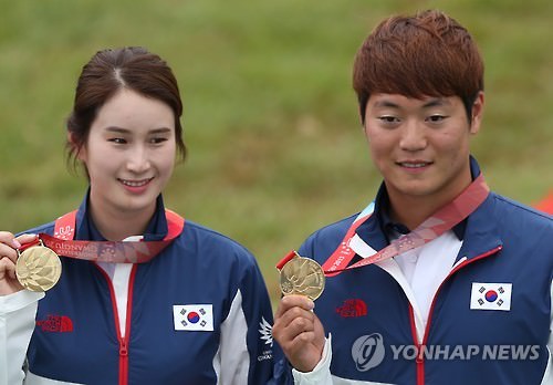 8日，韩国射箭选手奇甫倍（左）和李承润夺得光州大运会射箭反曲弓混合团体赛冠军。（韩联社）