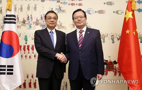 资料图片：1日，在韩国国会，李克强和郑义和（右）亲切握手。（韩联社）
