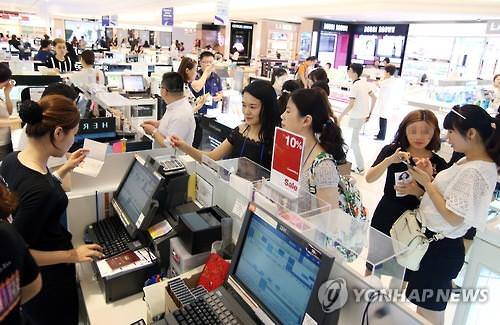 资料图片：韩国一免税店内，游客们正在购物。（韩联社）