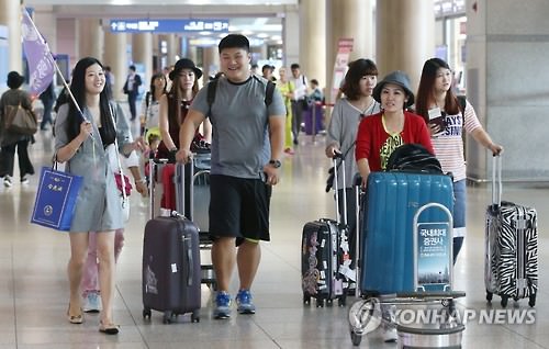 图为大批中国游客通过仁川国际机场入境。（韩联社）