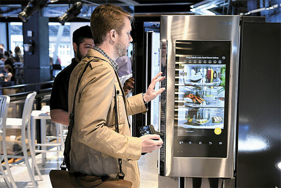 图为美国的一名顾客正在察看具有物联网功能的三星冰箱。（图片来源：三星电子）