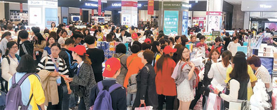 图为在免税店愉快购物的游客们。【照片 新世界百货商店】