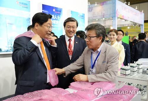 5月13日，在中国西安，韩国产业通商资源部长官周亨焕（左一）参观丝博会韩国国家宣传馆。