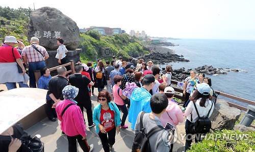 资料图片：在济州一景点，游客人头攒动。（韩联社）