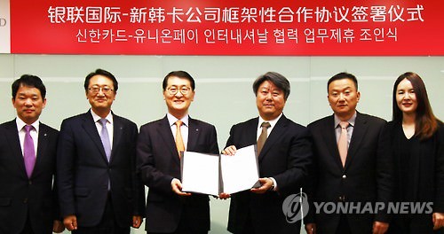 12月22日，在中国上海银联国际总部举行的新韩卡和银联国际合作协议签署仪式上，新韩卡社长魏圣昊（左三）和银联国际首席执行官蔡剑波（右三）及相关人士合影。（韩联社）