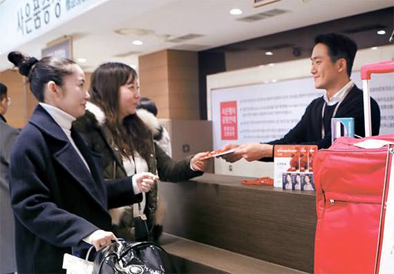 图为中国游客正在位于首尔小公洞的乐天百货总店领取赠品。（照片来源：乐天百货）