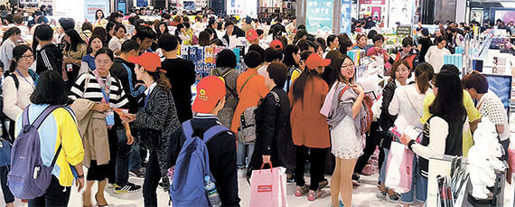 图为在比之前卖场更宽阔的新世界免税店釜山店享受购物的中国游客们。[照片来源：新世界免税店]