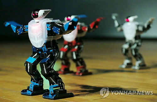 资料图片：2014年8月5日，“2014年全球机器人营地”（Global Robot Camp）开幕式在仁川市松岛国际大学举行。图为一组机器人在进行舞蹈表演。（韩联社）