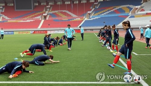 资料图片：韩国女足在平壤足球场热身。（韩联社）