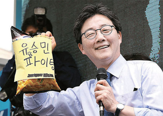 图为8日下午在首尔安岩洞高丽大学附近举行游说活动的正党总统候选人刘承旼手持从支持者手中得到的礼物。（图片来源：林贤东（音）、全民奎（音）记者）
