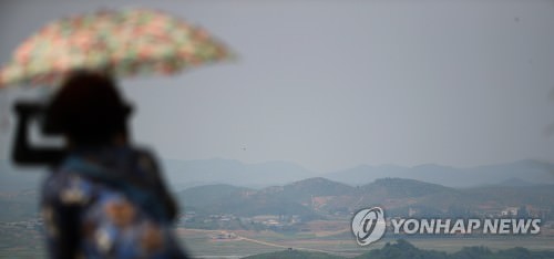 资料图片：6月1日下午，在韩国京畿道坡州乌头山统一展望台，一名游客眺望朝鲜黄海北道开丰郡。（韩联社）