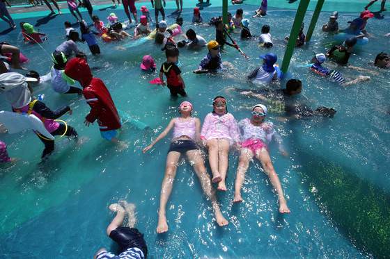 图为本月9日孩子们正在开放的首尔面牧洞中浪川水上游乐场消暑。（图片来源：朴钟根 记者）
