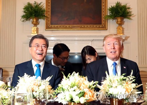 资料图片：当地时间6月29日，在美国白宫，文在寅（左）和特朗普在晚宴上亲切对话。（韩联社）