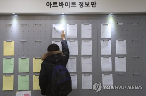 资料图片：2017年3月份，在首尔建国大学，一名学生在查看打工招聘公告。（韩联社）