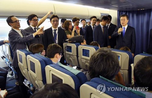 当地时间9月21日，文在寅在回国的专机内与随行记者谈话。（韩联社）
