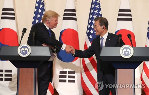 资料图片：11月7日，在青瓦台，韩国总统文在寅（右）与美国总统特朗普共同会见记者并握手。（韩联社）