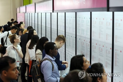 资料图片：2017年9月13日，在首尔韩国国际会展中心（COEX），大韩贸易投资振兴公社（KOTRA）举办2017外国留学生招聘博览会，吸引众多留学生参加。图为各国留学生查看招聘信息。（韩联社）