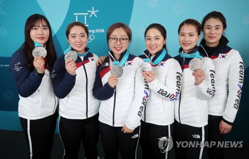 资料图片：2月25日，在江陵冰壶中心，韩国女子冰壶队在2018平昌冬奥会女子冰壶项目中摘得银牌后胸挂银牌合影留念。（韩联社）