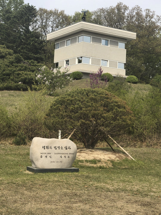 A stone inscribed with the names of the two leaders and the phrase “Plant peace and prosperity,” （ Tree-planting）