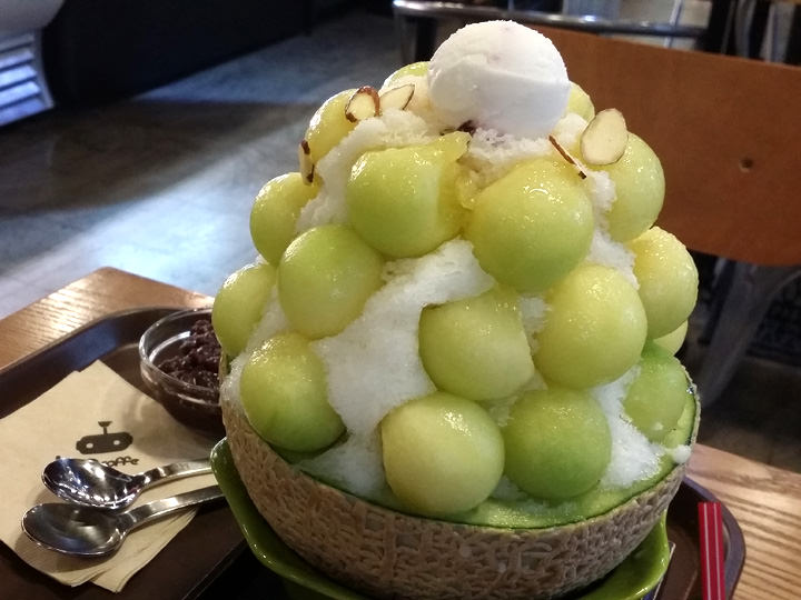 先把刨冰上面的哈密瓜吃完,再把另奉上的红豆撒在沙冰上一同享用.