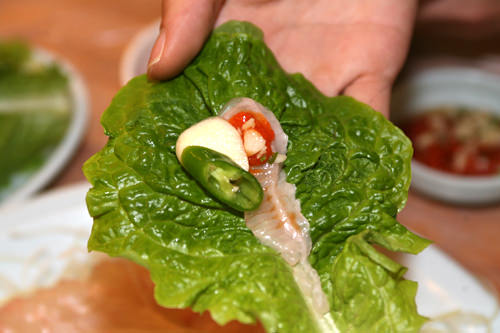韩国人一样蘸海鲜辣酱后用生菜包着吃