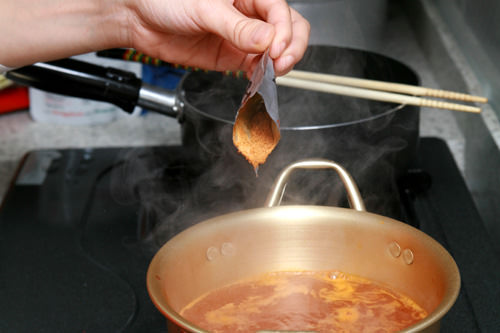 2. 水煮滚后,放入酱料包。