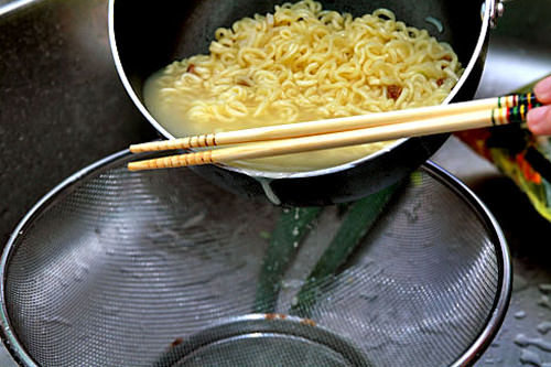 3. 留下约8汤匙的水并将其余热水倒掉,再将酱料包和橄榄油与面混合。