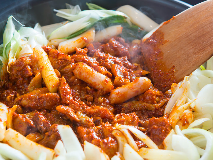 现在铁板中央将鸡肉和蔬菜混炒