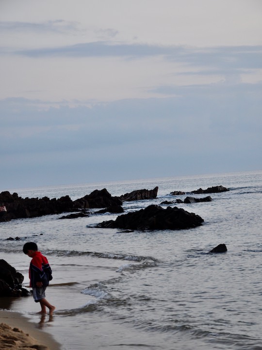 在海边等待日出的小男生