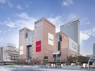 “新世界报货 江南店”(照片前面的建筑)