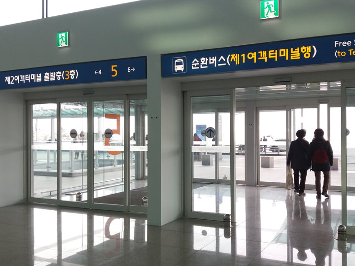 第二航站楼5号出口可看到前往第一航站楼的穿梭巴士的标识