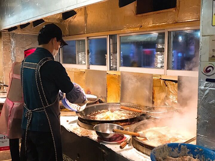 店里的大叔正在忙碌的做炸鸡