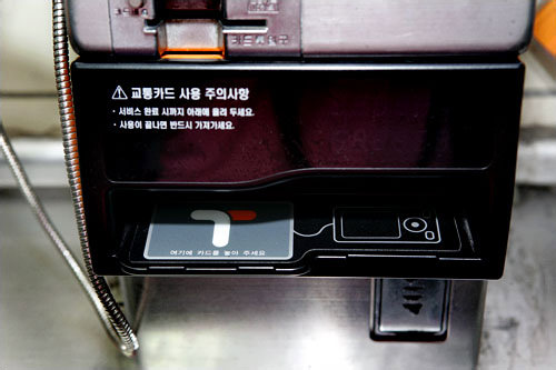 拿起话筒,
将T-money卡放入电话读卡部分