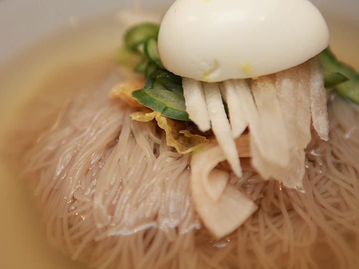 冷面放有煮鸡蛋,黄瓜,泡菜等