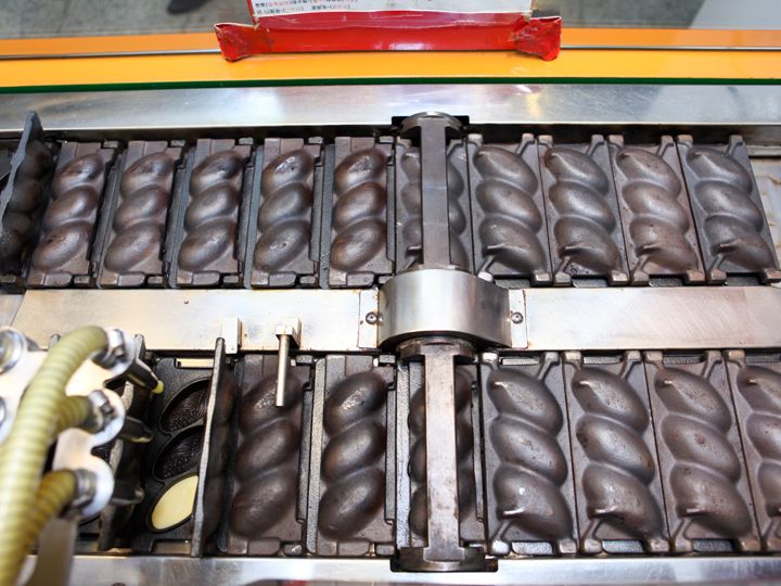 封盖后随着铁板滚动,甜品逐渐烘烤完成