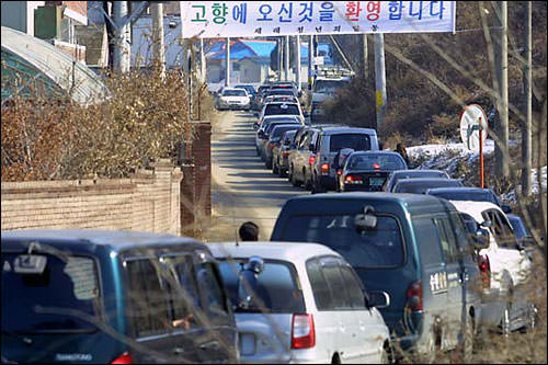 去墓园的路也堵成这样!横幅上写着”欢迎归乡”的字样!