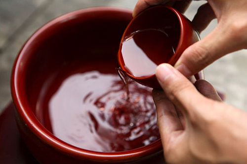 参礼者将酒倒进容器,反复斟酒