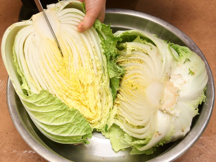 2. 把刚刚切成两半的白菜继续从根部二等分,让盐水更全面地覆盖在白菜表面及内侧。