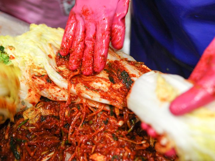 从菜叶到菜根,一片片均匀细致地涂抹泡菜酱。