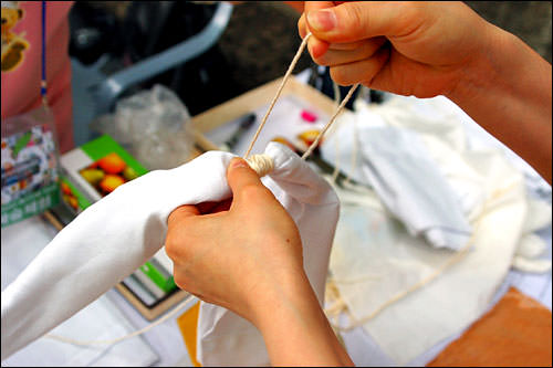 1. 准备一块棉布,不想染色的地方用绳子系上,为了防止黄土沾上,需要系的紧一些。