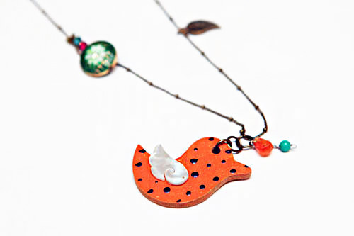 用轻便的桔黄色木材做成的小鸟底板上,又贴着用贝壳做成的小鸟,可爱又独特。很适合休闲的装扮