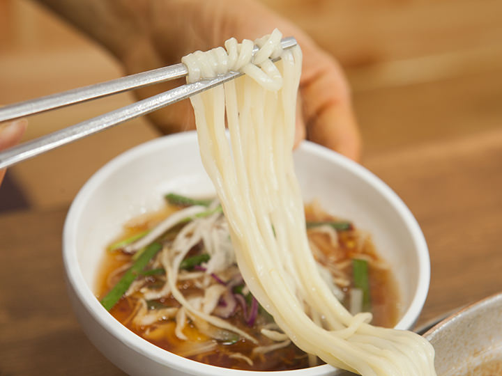 将面条沾上特制酱料